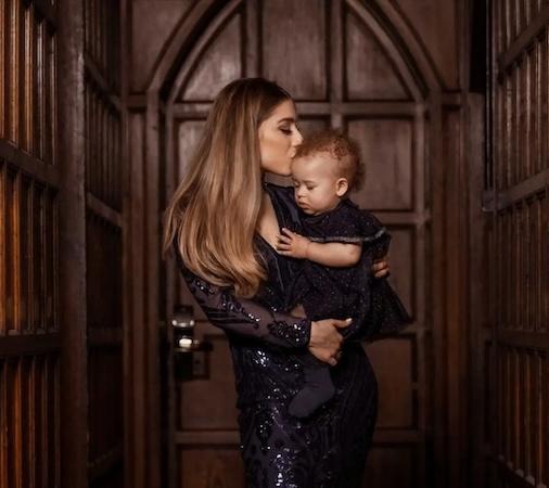 Michaela holding and kissing her daughter.